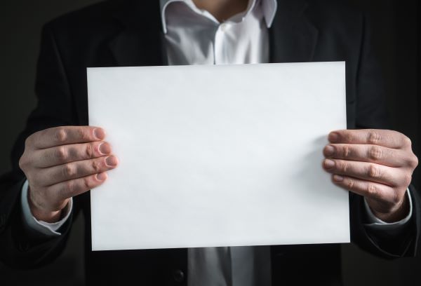 man holding white sheet of paper