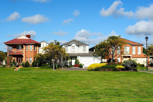 Suburban street with three houses that are resolving boudndary disputes and discussing property lines.