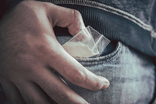 A man hiding controlled substances in his pocket; different types of possession can impact the process for some criminal cases.