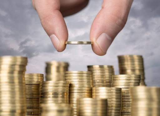 A man’s hand stacking coins to represent the importance of asset protection for entrepreneurs.